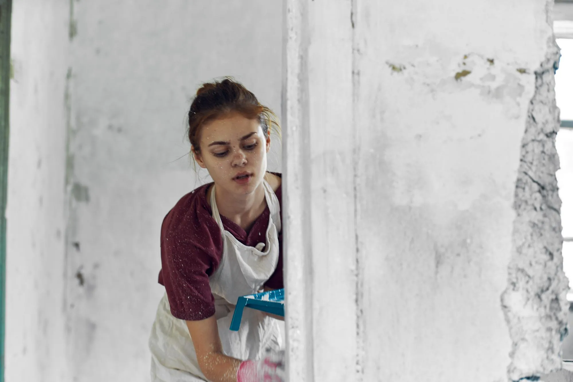 Portrait of young woman standing against wall