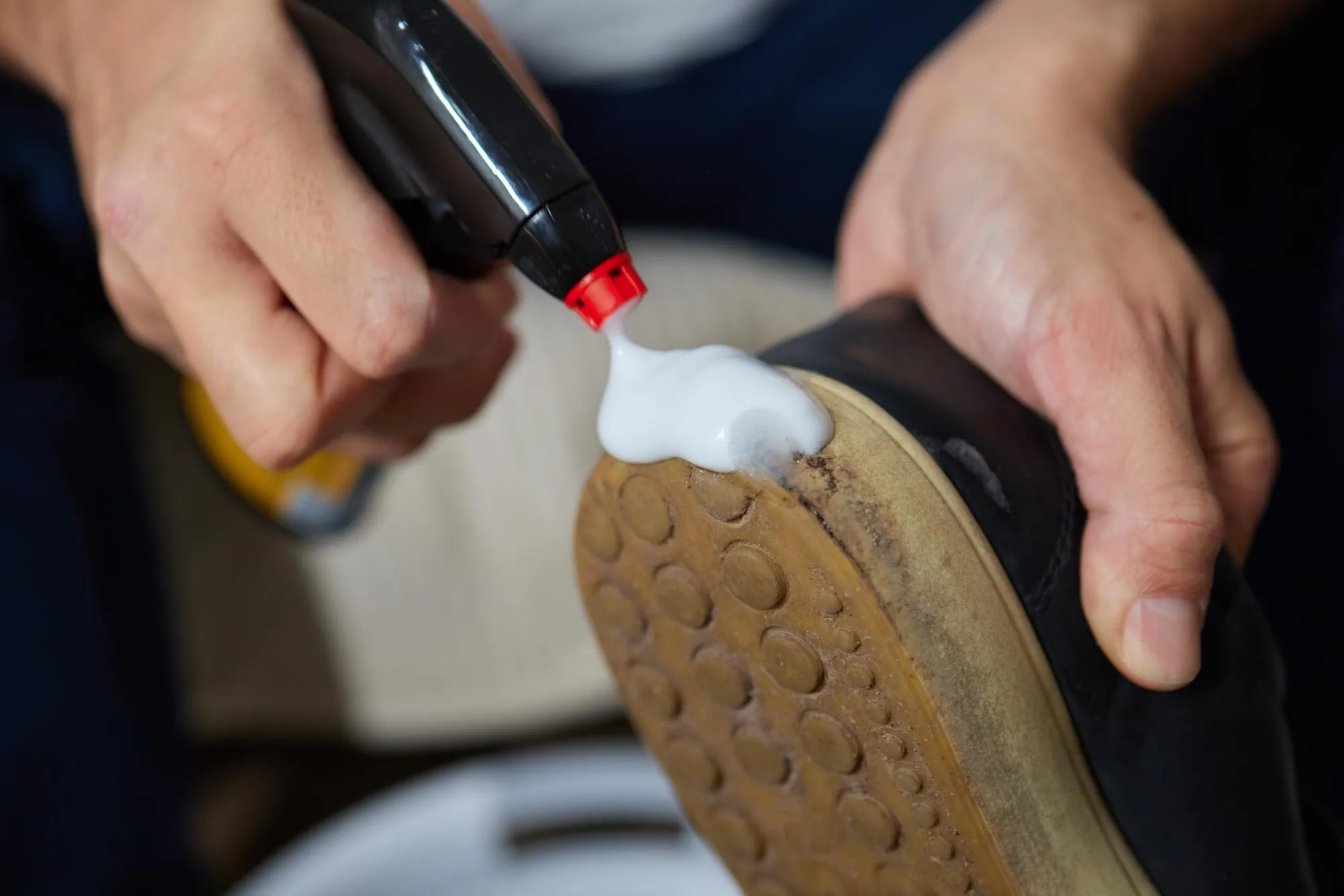 Cleaning suede sneakers A worker in a shoe workshop cleans a pile of shoes