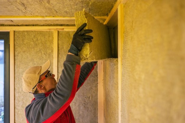 Contractor Installing Mineral Wool Inside Garden Shed Walls
