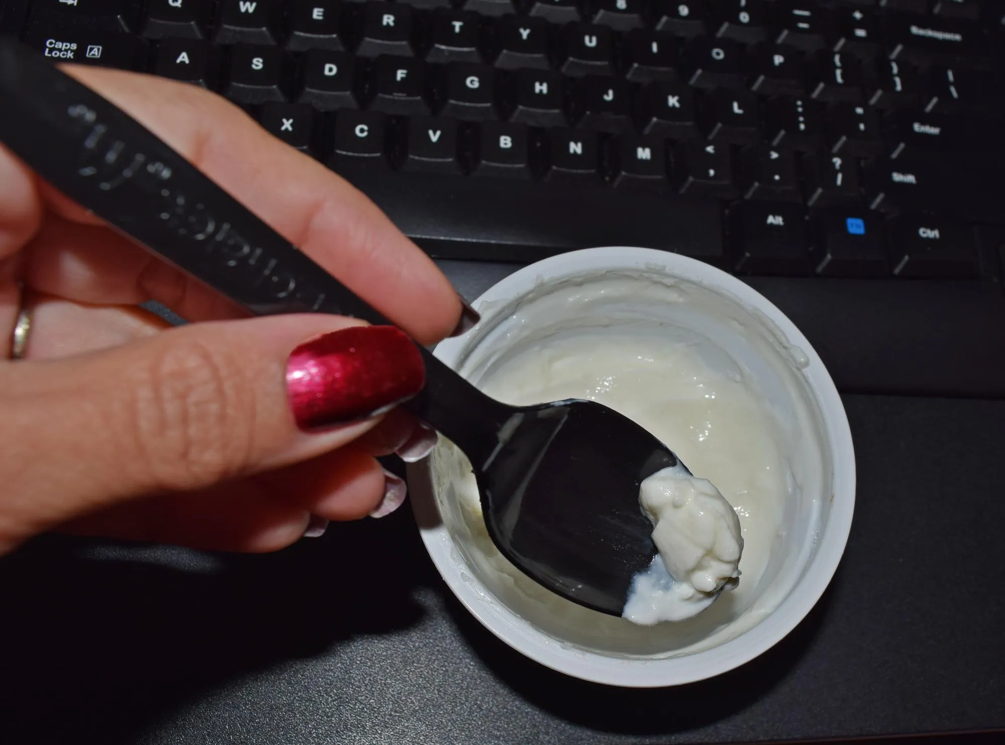 Cropped image of woman having dessert by keyboard
