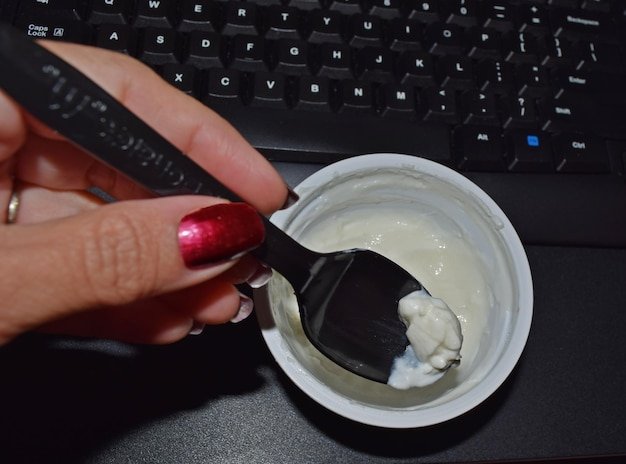 Cropped image of woman having dessert by keyboard
