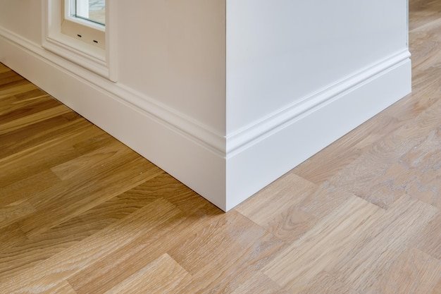 Detail of corner flooring with intricate crown molding and plinth