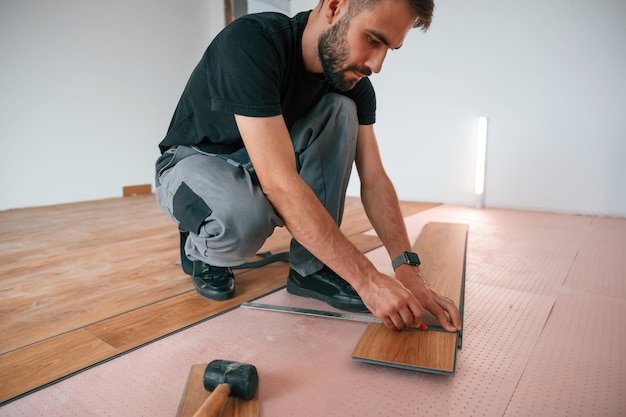 Hand work Man is installing new laminated wooden floor