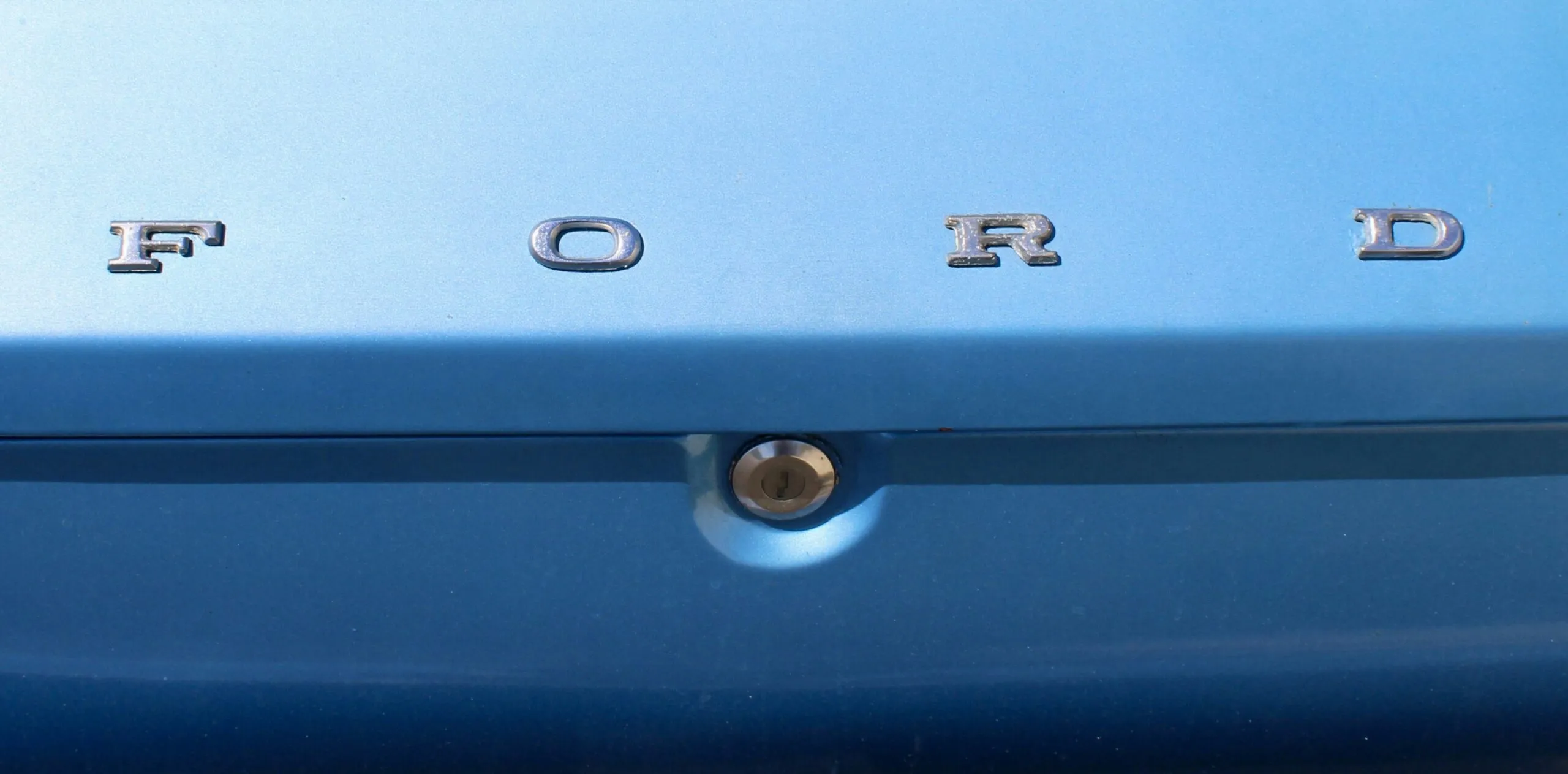 Close up of the ford logo on a blue car.