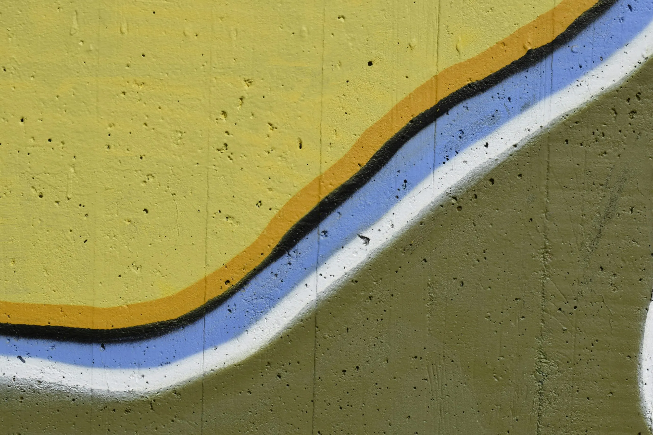 a painting of a yellow and blue wave on the side of a building
