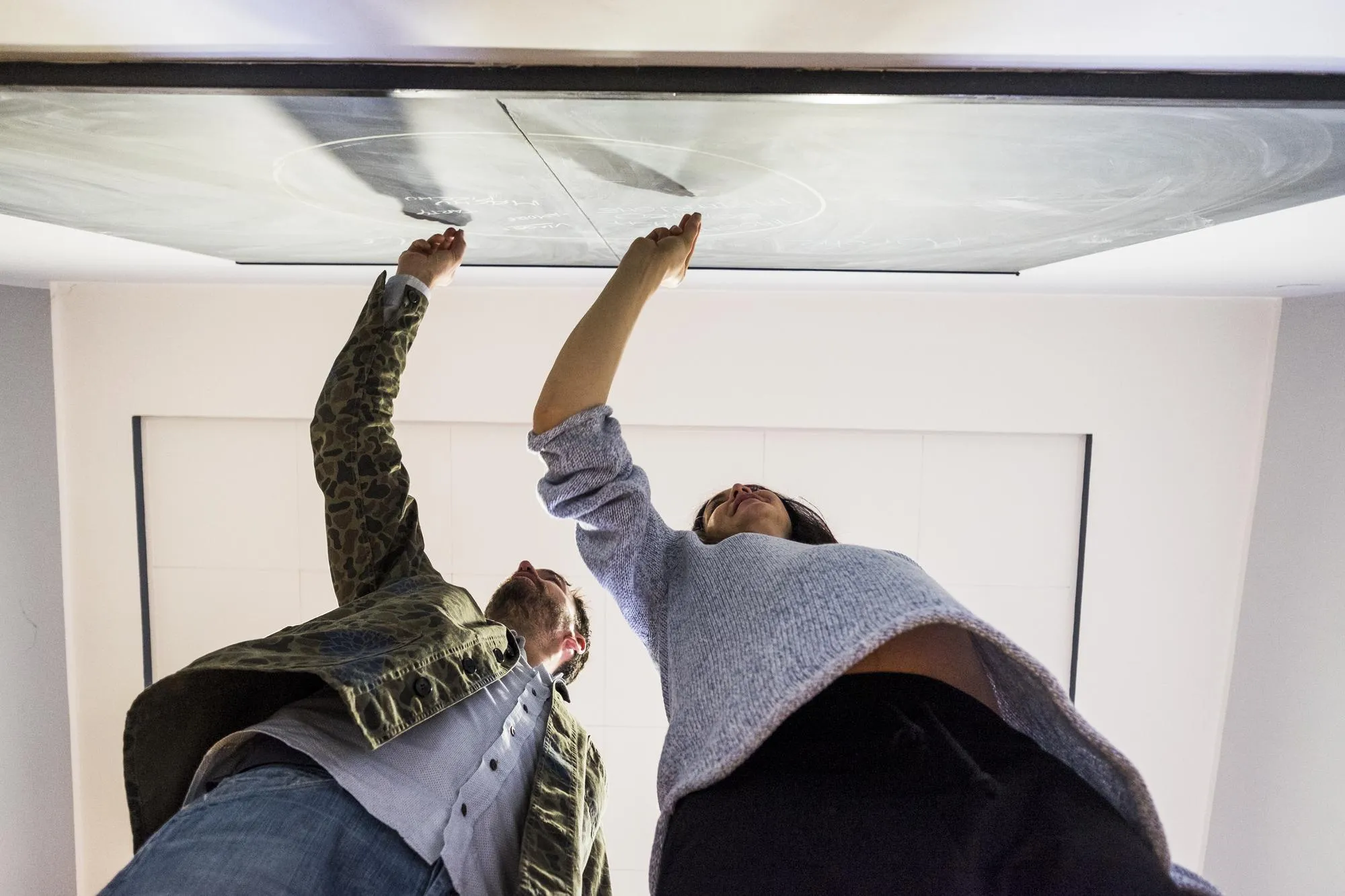 Low angle view of couple writing on blackboard at home