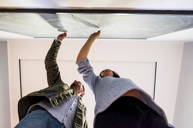 Low angle view of couple writing on blackboard at home