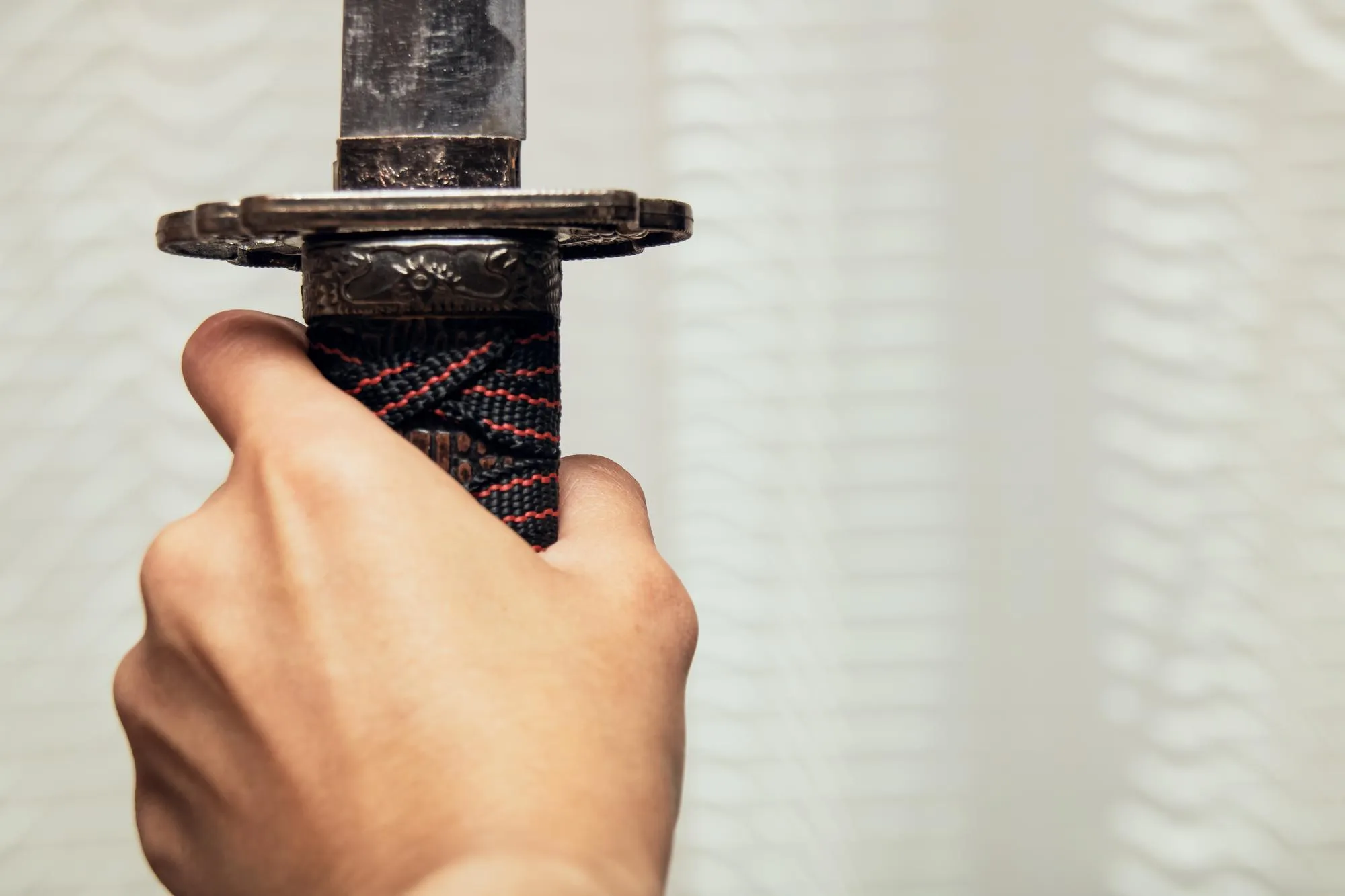 Samurai sword in hand close up copy space