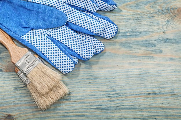 Set of paintbrushes safety gloves on wooden board construction concept