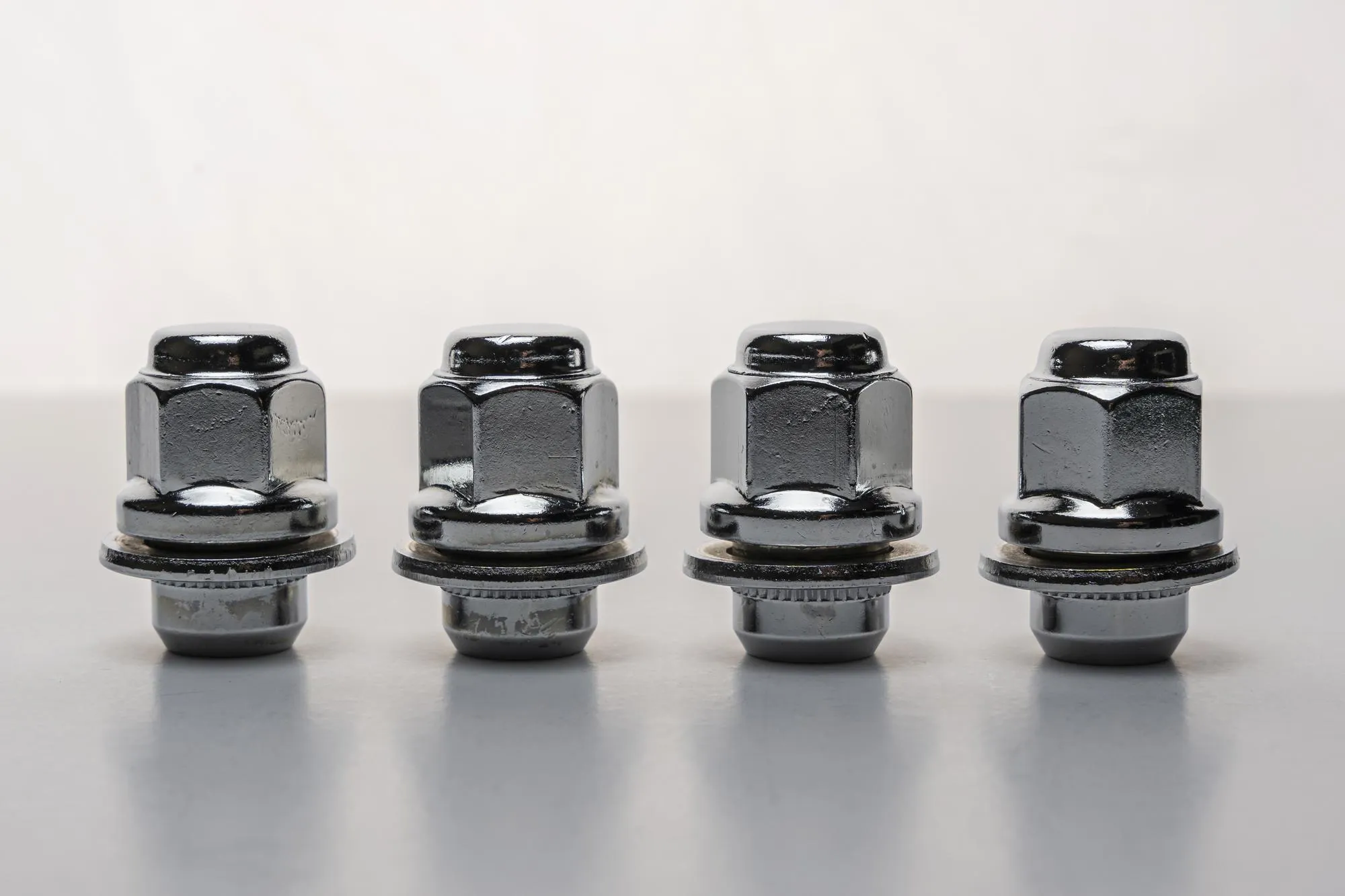 Shiny new wheel nuts on a white background