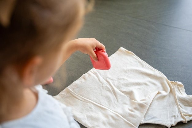 Back view of little girl with a stamp with a name for signing childrens things identification of