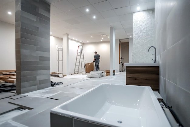 Bathroom renovation with new tiles being installed worker in the background modern sleek design