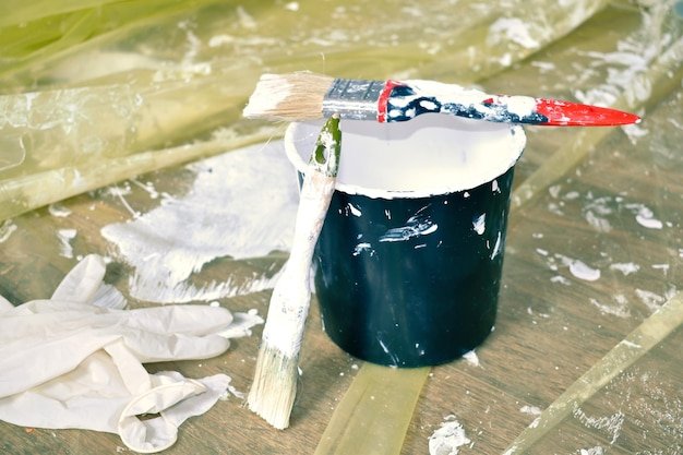 bucket of white paint and brushes construction finishing work inside Home repair