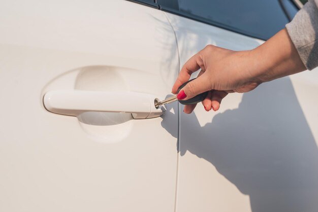 Closeup hand woman holding key opening car door.