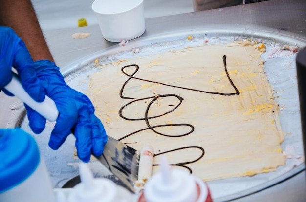 Cropped hand making ice cream on table