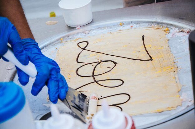 Cropped hand making ice cream on table
