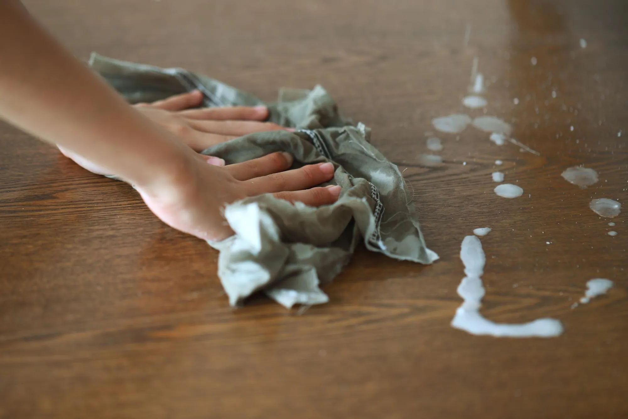 Cropped hands cleaning hardwood floor