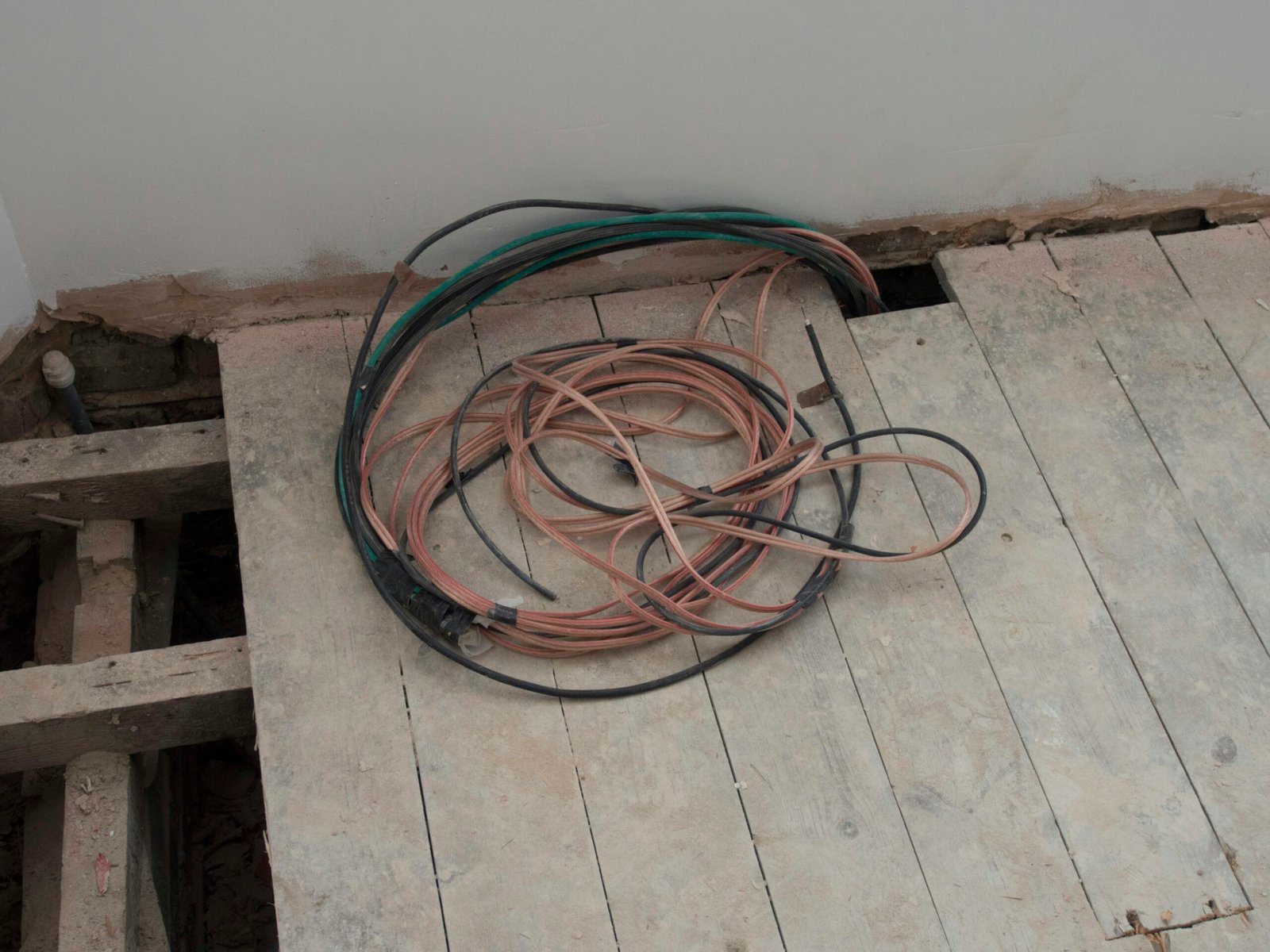 A pile of wires sitting on top of a wooden floor