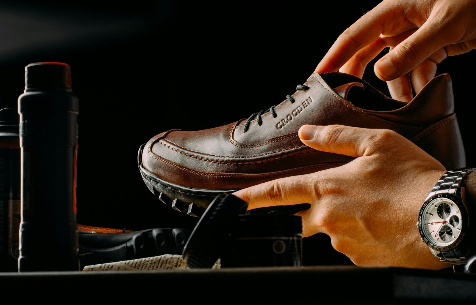 a person tying a pair of brown shoes