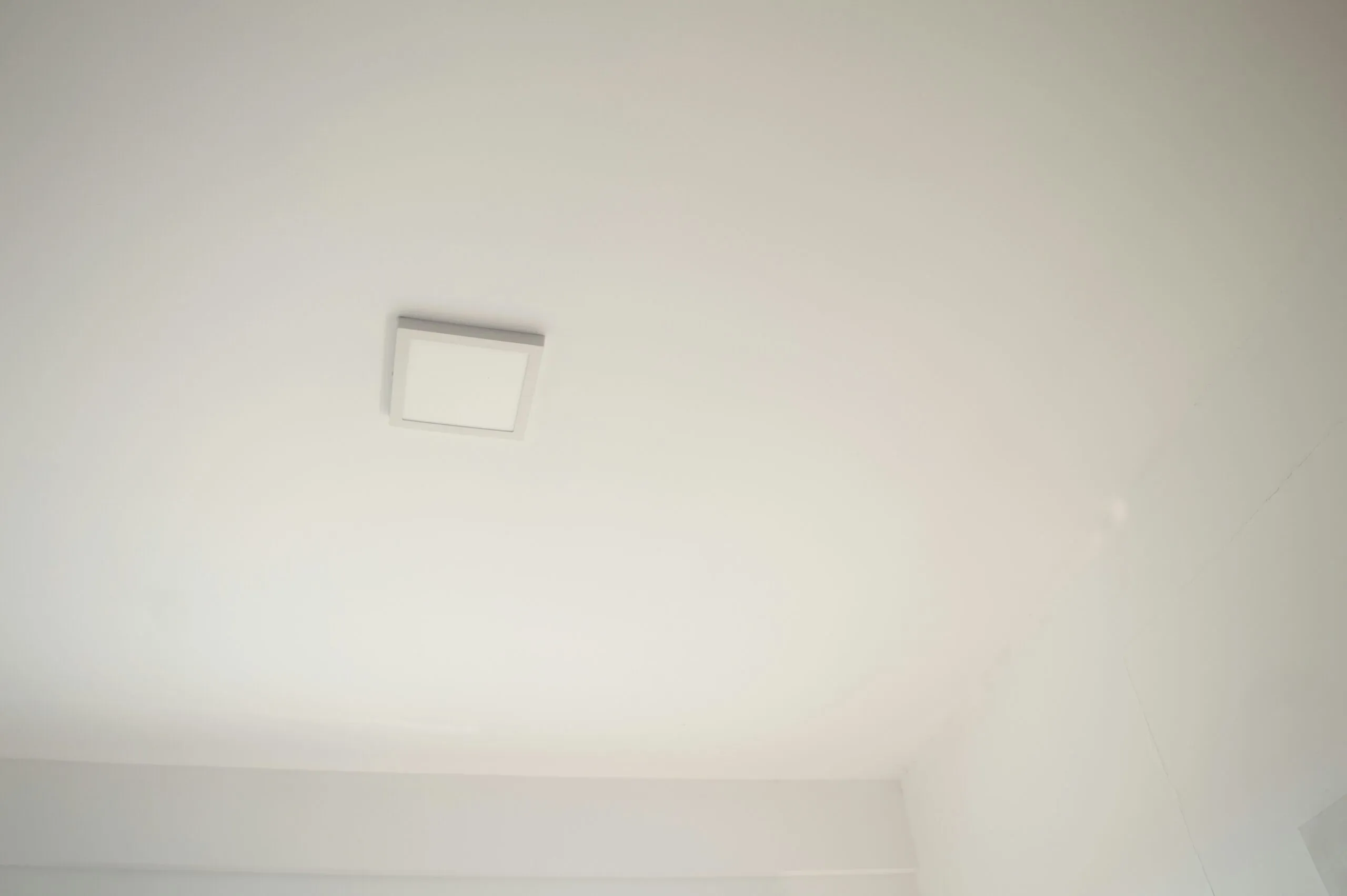 a bathroom with a toilet and a white ceiling