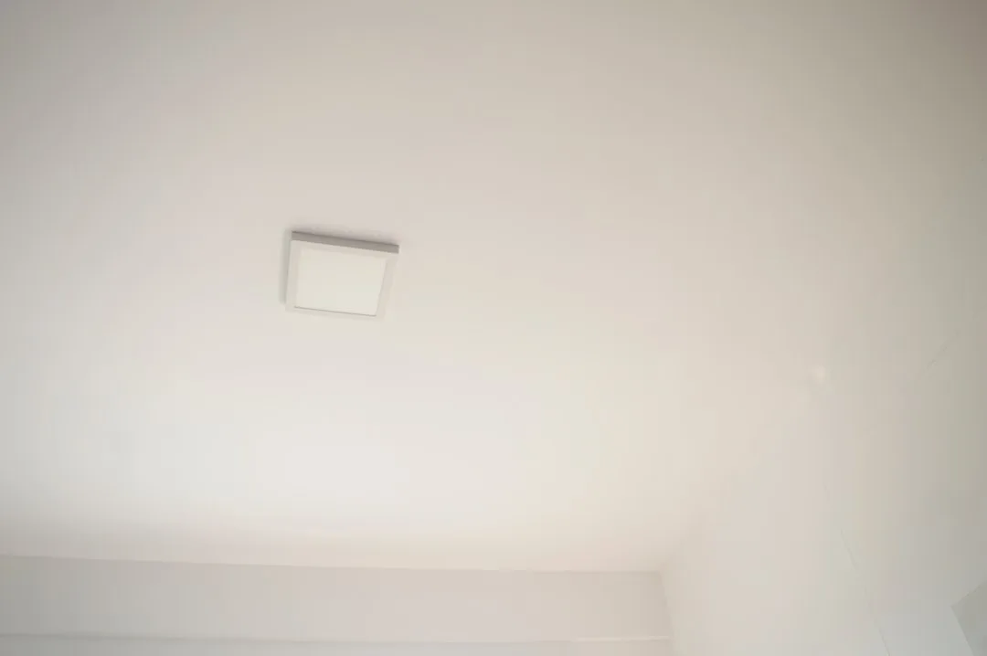 a bathroom with a toilet and a white ceiling