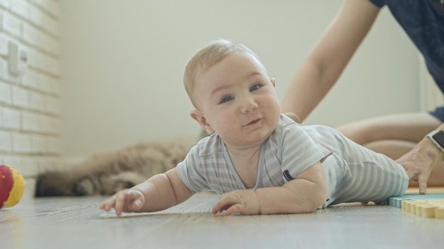 A little funny smiling baby on the floor looking in the camera