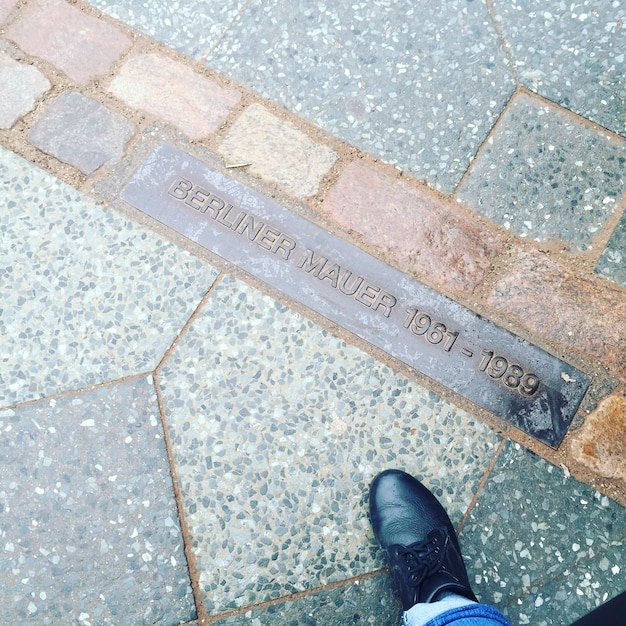 Low section of man standing on sidewalk
