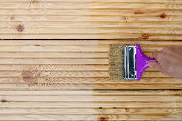 Painting new wooden boards for patio by special protective oil