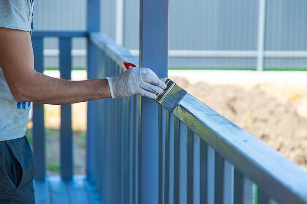 Painting a wooden board with a gray brush Selective focus
