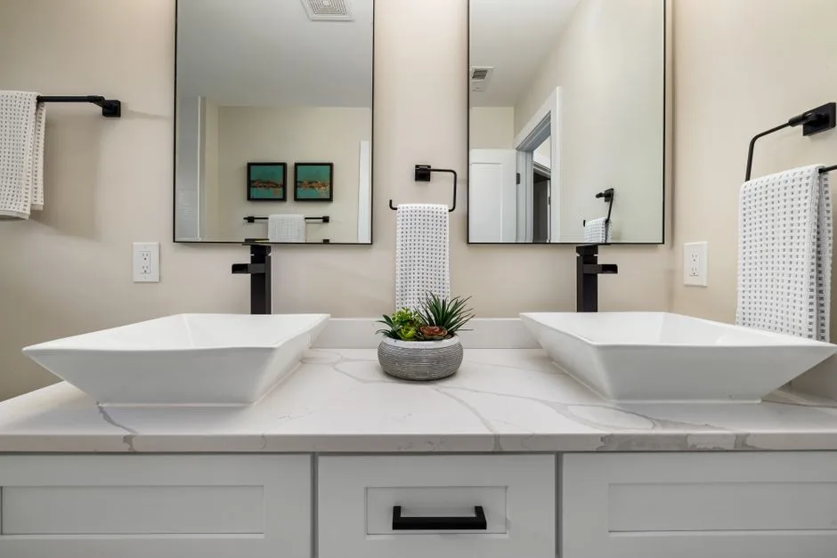 Contemporary bathroom design featuring double vessel sinks with sleek faucets.