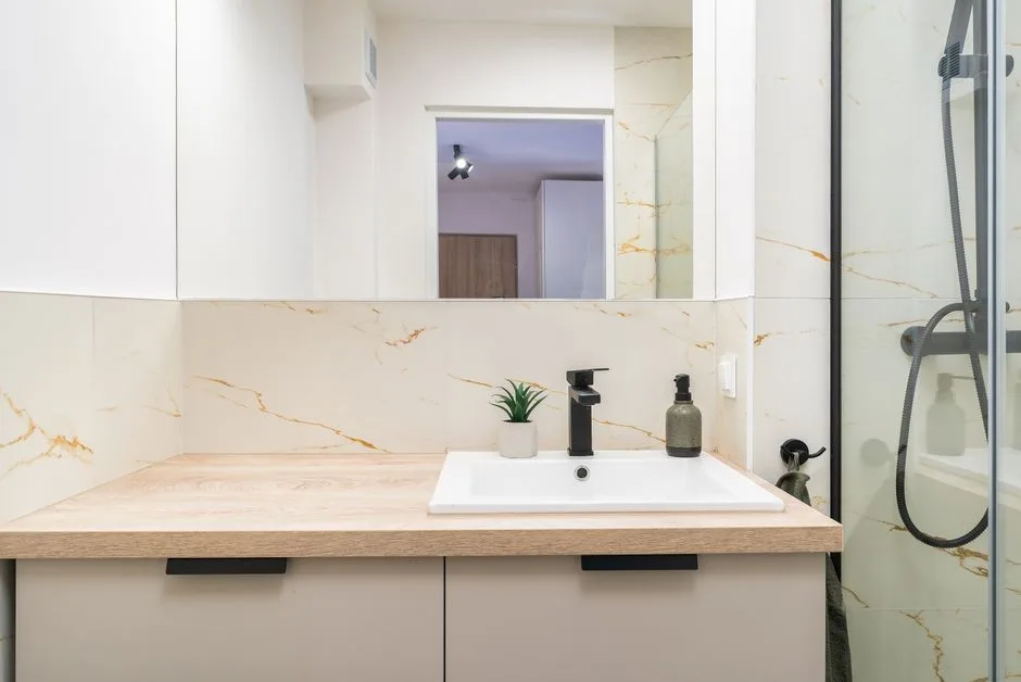 A minimalist bathroom vanity with wood countertop and elegant fixtures.
