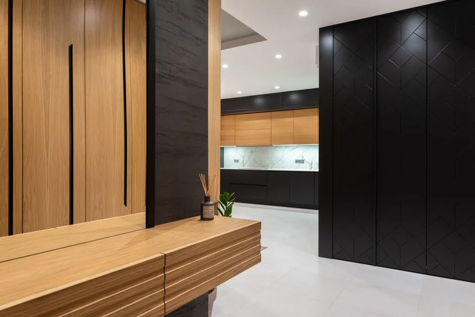 Modern bright house interior with cabinets and mirror in hall near entrance to kitchen