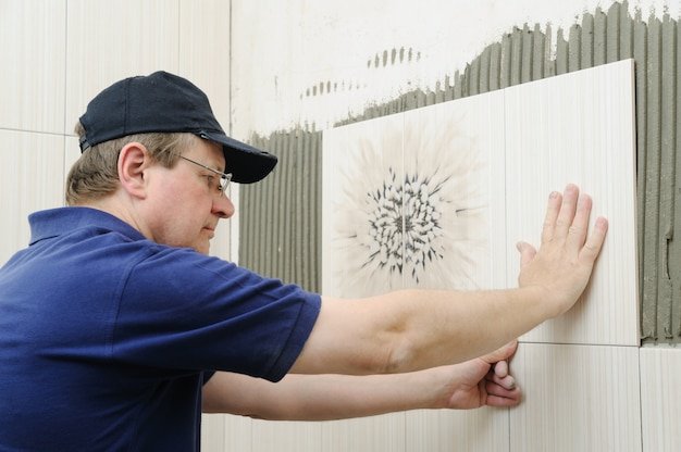Tiler is installing a ceramic tile.