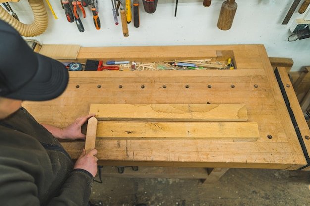 Top view of a carpenter assembling a furniture on his wooden desk
