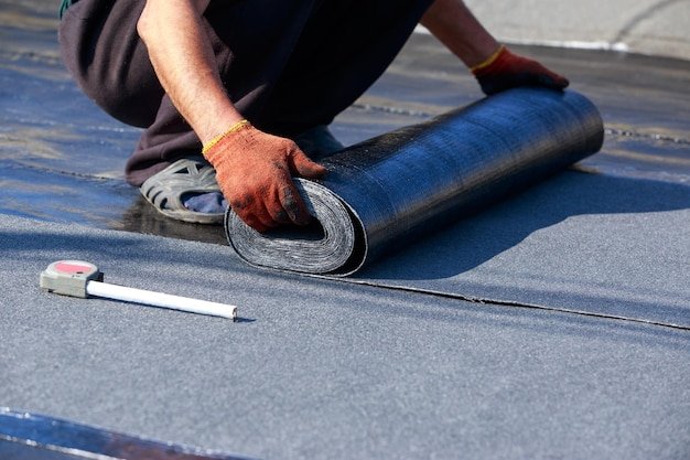 Worker puts roofing material