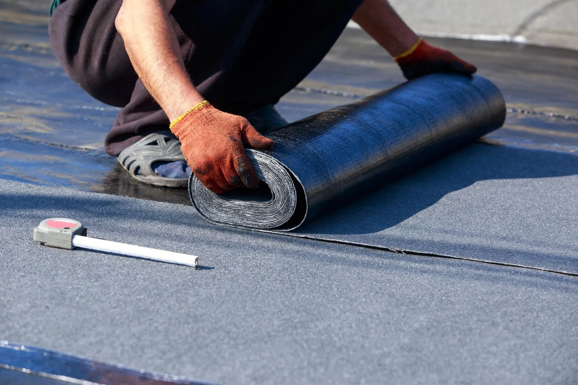 Worker puts roofing material