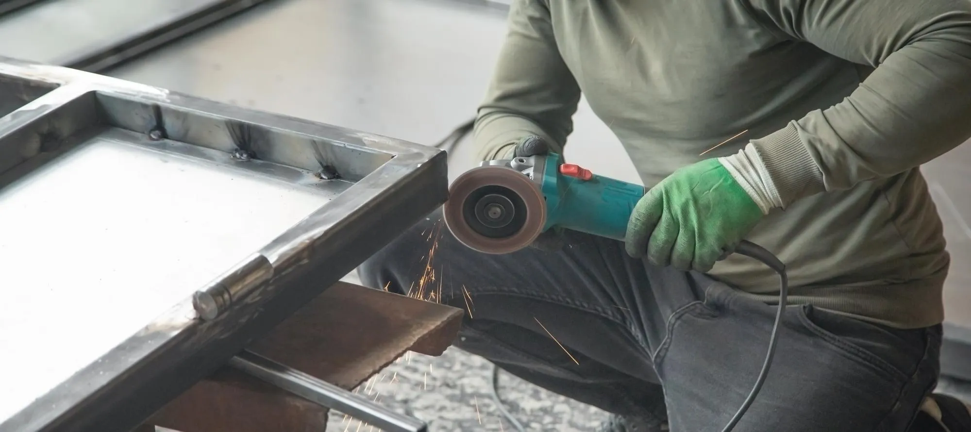 Worker using angle grinder Cutting detail of iron gate