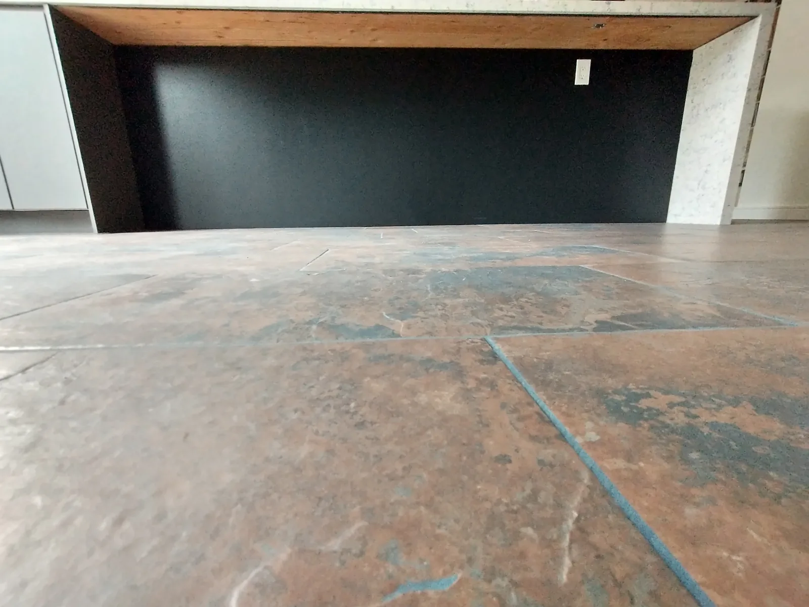 When installing an Ikea kitchen ("Sektion" cabinet system) with the cabinet frame color not matching the front element color, there must not any cabinet frame sides be exposed. In this example, an additional cover panel was installed to cover the side. Here, the cover panel is extended down to the floor to match the shape of the opposing countertop waterfall.