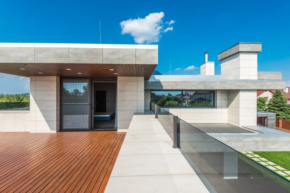 Sleek modern terrace featuring wood decking and blue sky background.