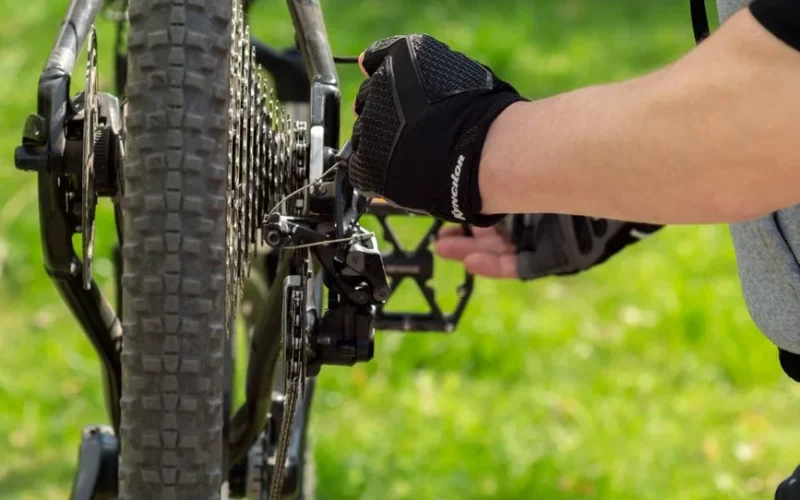 Person adjusting bike gears outdoors in Wrocław, Poland.