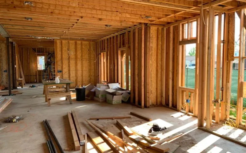 Sunlit interior with wood framing, showcasing home construction progress.