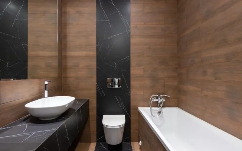 Sleek modern bathroom featuring wood paneling and marble accents, with a white basin and bathtub.