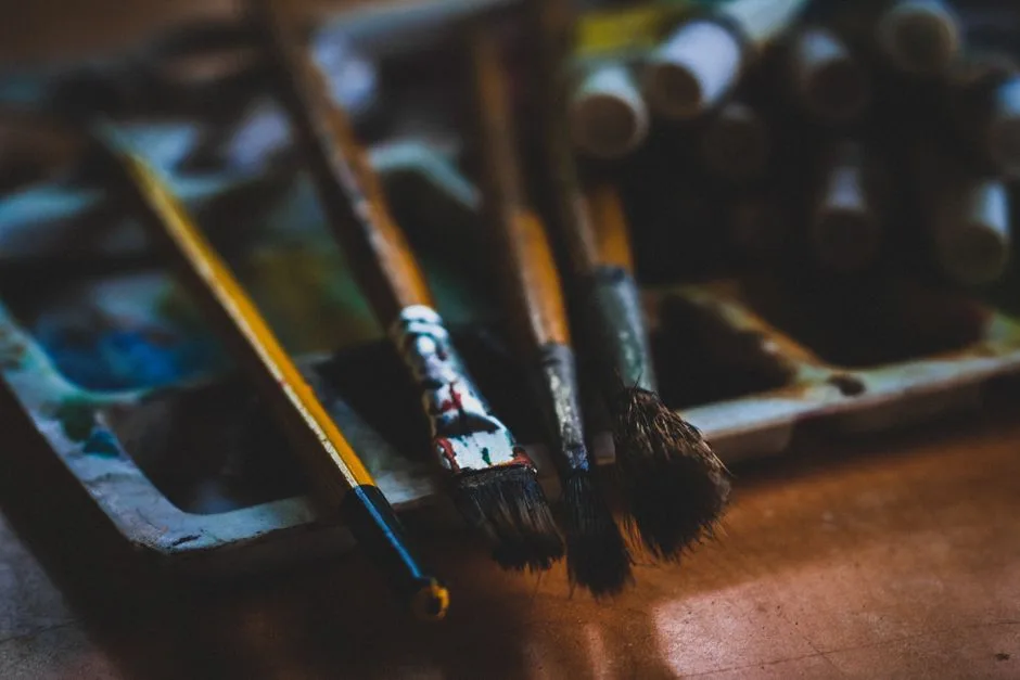Detailed view of various paintbrushes on a color palette, perfect for art inspiration.