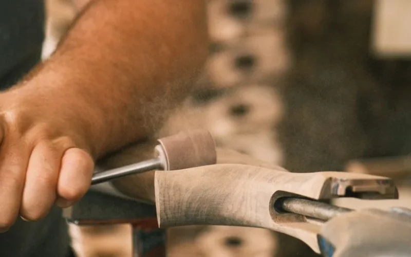 Skilled artisan shaping wood on a lathe, emphasizing craft and precision.