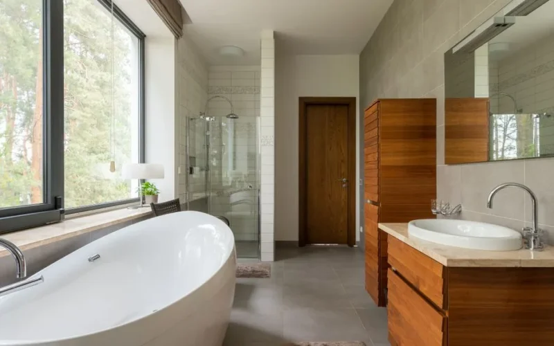 Interior of modern spacious bathroom with rectangular shaped mirror and glass shower cabin