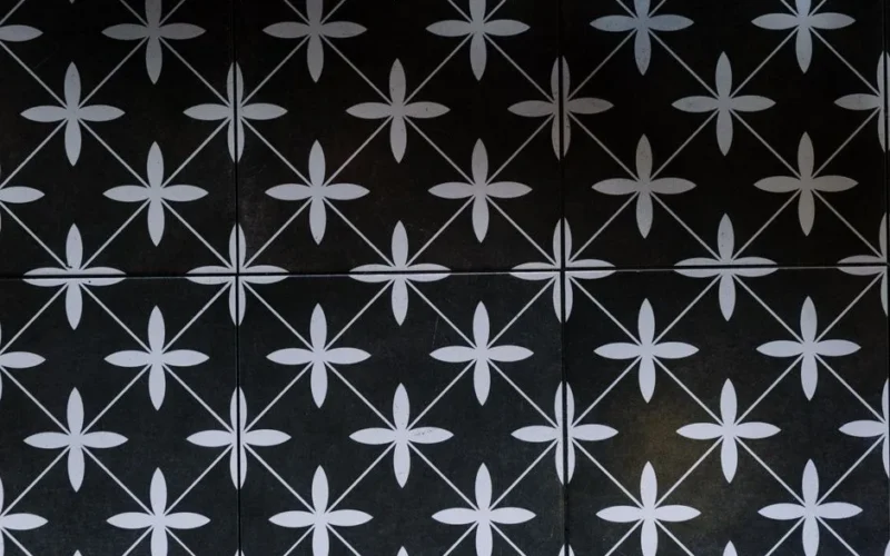 Stylish black and white geometric tile pattern with floral motifs and symmetry, perfect for home decor or design inspiration.