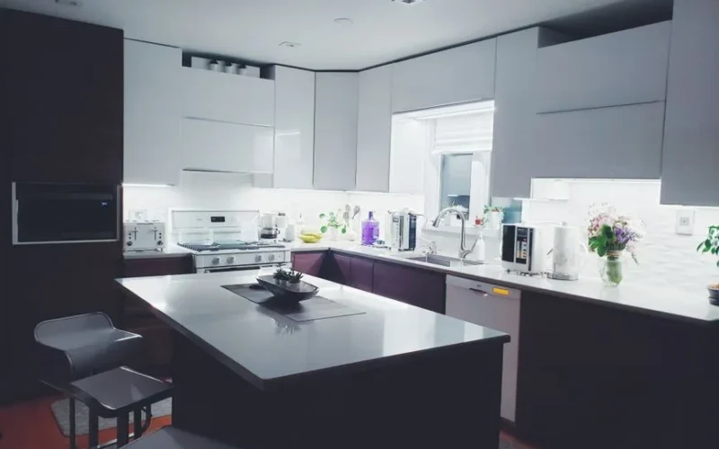 Contemporary kitchen interior with sleek white cabinets and island, perfect for a minimalist aesthetic.