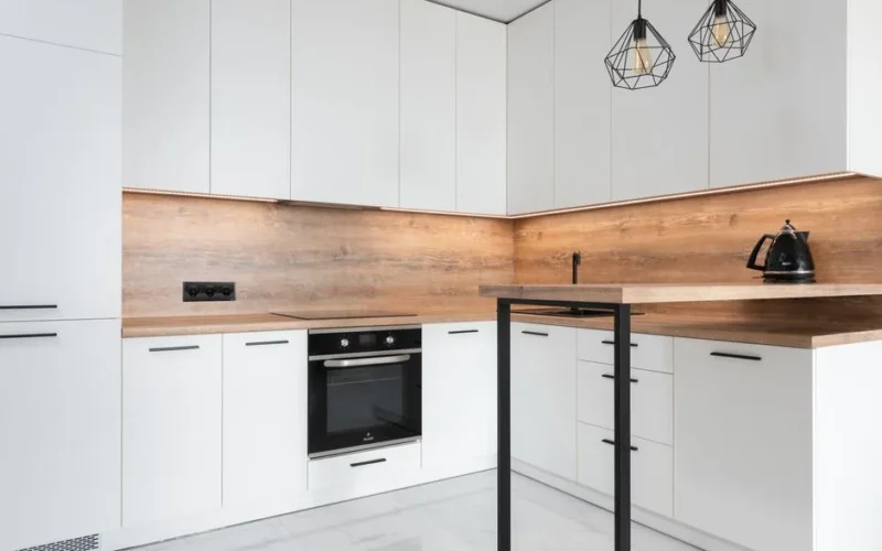 Modern kitchen with contemporary interior with metal geometrical lamps and new white cabinets