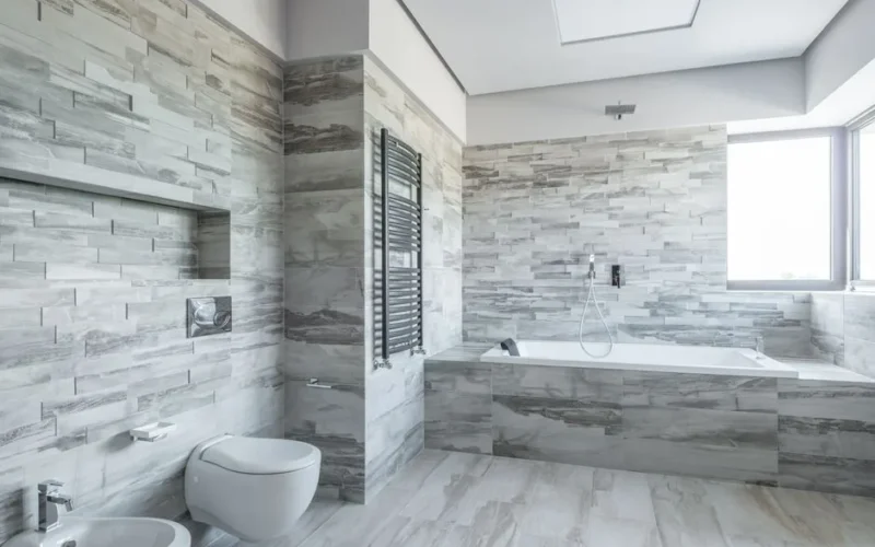 A spacious and stylish bathroom featuring modern design elements like a sleek bathtub and stone tiles.