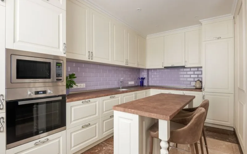 Stylish white kitchen featuring marble countertops and a microwave. Perfect for modern interiors.